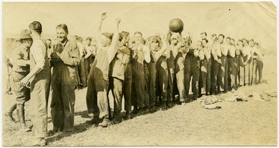 Men Standing in Lines Passing a Ball Over Their Heads to the People Behind Them by Carl Michel